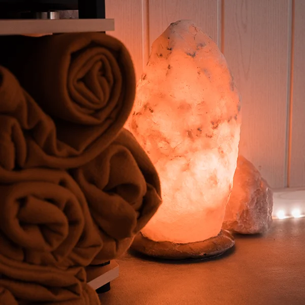 Salzsteinlampe und orangene Handtücher
