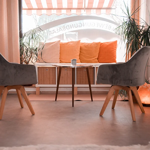 Warteraum des Studios mit einer gemütlichen Bank, zwei Stühlen und einem Tisch